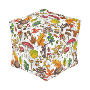 Autumn mushrooms, leaves, nuts and berries on whit pouf