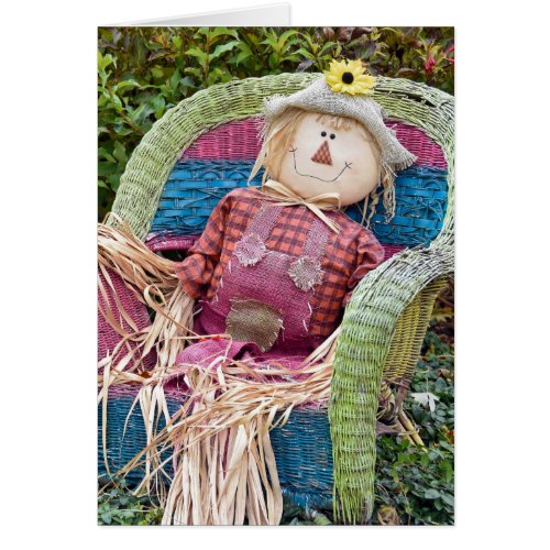 Autumn scarecrow in wicker chair