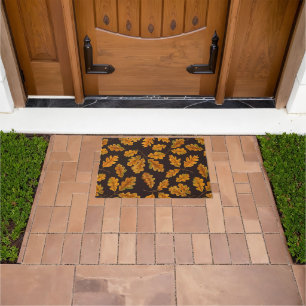 Autumnal oak leaves on dark brown doormat