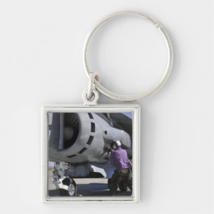 Aviation fuel technician attaches a fuel line keychain