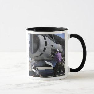 Aviation fuel technician attaches a fuel line mug
