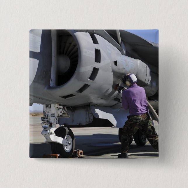 Aviation fuel technician attaches a fuel line pinback button (Front)