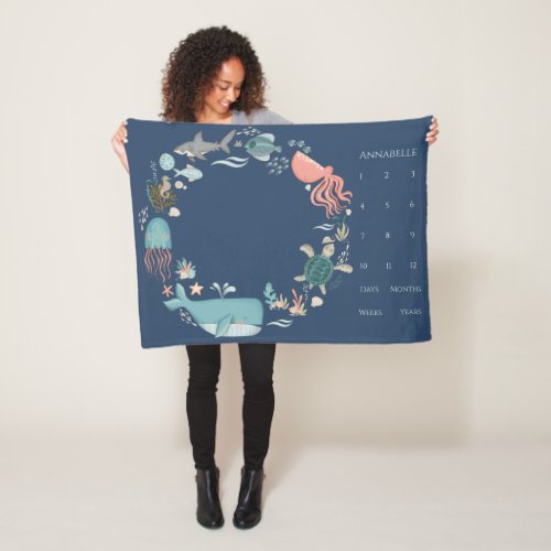 Baby Milestone Blue Under the Sea Animal Wreath Fleece Blanket - Surround your sweet baby in a delicate wreath of watercolor ocean animals, on a dark blue background, with coral, shells, fish, octopus, whale and more! This design will make a lovely photo backdrop, featuring baby's name in coral type. The milestone markers for 1-12, to the right, are followed by the options of days, weeks, months and years, giving you many photo options. Thank you so much for supporting our small business, we really appreciate it! 
We are so happy you love this design as much as we do, and would love to invite
you to be part of our new private Facebook group Personalized Gifts for Any Occasion. 
Join to receive the latest on sales, new releases and more! 
https://www.facebook.com/groups/270127958409002  Copyright Personalized Home Decor, all rights reserved.