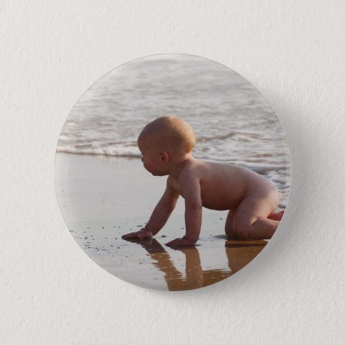 Baby playing in the sand on the beach pinback button