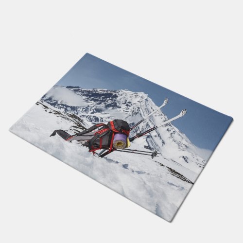 Backpack and skis on snow on background volcano doormat