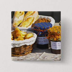 Basket with croissants and chocolate breads. pinback button