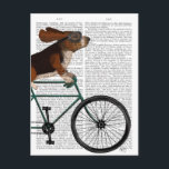 Basset Hound on Bicycle Postcard<br><div class="desc">Basset Hound on Bicycle by Fabfunky. Features a basset hound riding a bike with a book page for a background. | 192050D</div>