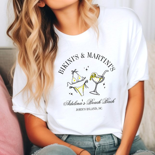 Beach Bachelorette Party Favor Social Club T-Shirt (Woman in a casual setting wearing a white T-shirt with a fun design of a bikini and martini glass. )
