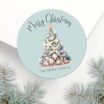 Beach Christmas Classic Round Sticker<br><div class="desc">Celebrate in sunny style with this festive round sticker, perfect for your tropical holiday celebration. A large Christmas tree made of beach shells, starfish, and coral sits in the center, bringing a fun and whimsical coastal vibe to your event. The background is teal blue, with gray fonts adding a soft,...</div>