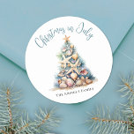 Beach Christmas In July Classic Round Sticker<br><div class="desc">Celebrate in sunny style with this festive round sticker, perfect for your Christmas in July celebration. A large Christmas tree made of beach shells, starfish, and coral sits in the center, bringing a fun and whimsical coastal vibe to your event. The design features a teal blue and tan color palette...</div>