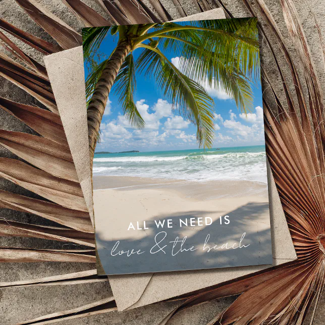 A wedding reception invite with a coastal theme. Palm trees are shown casting a shadow over a beachfront. 