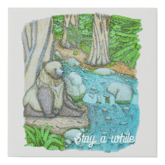 Bear sitting by a creek faux canvas print