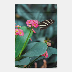 Beautiful butterfly on a pink flower garden flag