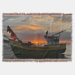 beautiful sunset over the sea and a fishing boat throw blanket