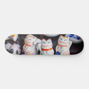 Beckoning cat figurines skateboard