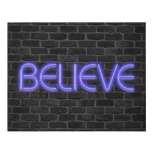 Believe text in neon lights on brick faux canvas print