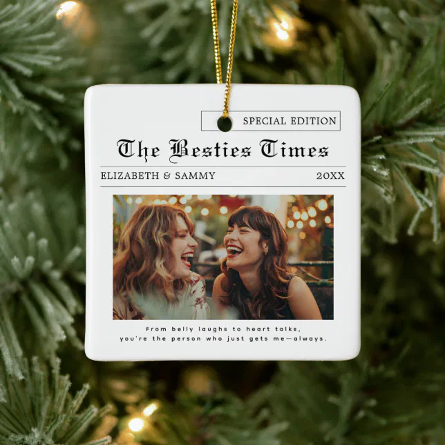 An ornament featuring two best friends titled "The Besties Times" is seen hanging in front of a Christmas tree.