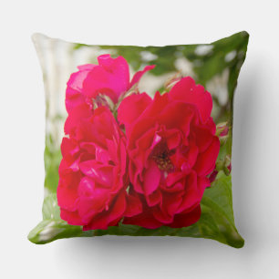 Big red roses in the garden throw pillow