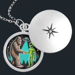 Bigfoot Meets Alien Locket Necklace<br><div class="desc">This whimsical image illustrates a friendly encounter between two legendary beings: Bigfoot and an alien. The scene, set against a starry night sky with silhouettes of pine trees, shows Bigfoot and the alien shaking hands under the beam of a UFO hovering above. Bigfoot, covered in brown fur, stands on the...</div>