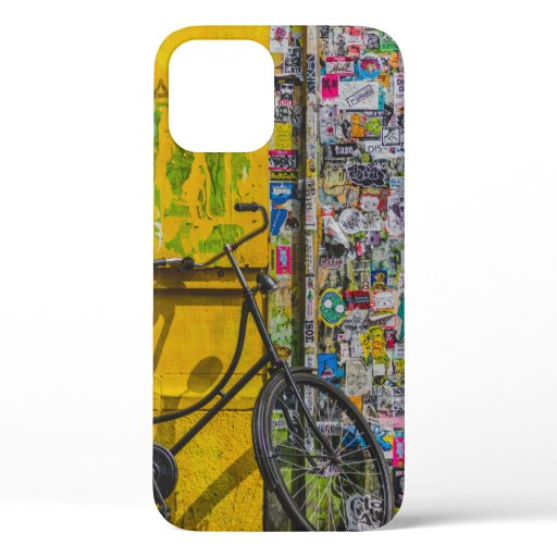 BIKE PARKED BESIDE WALL FULL OF STICKERS iPhone 12 CASE