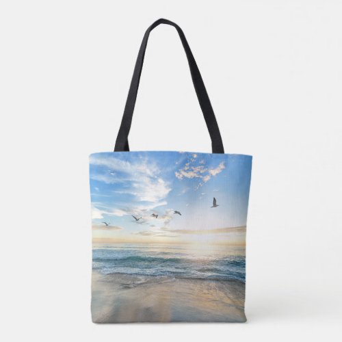 Birds in flight over the ocean tote bag