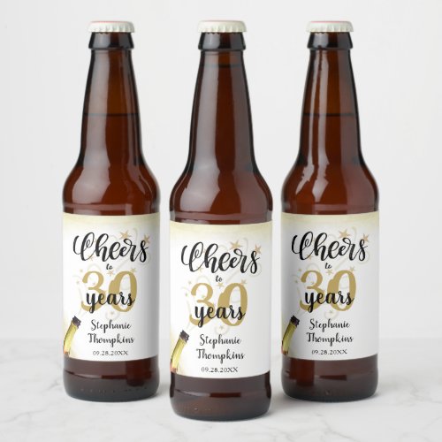 Birthday CHEERS TO # YEARS Black Gold Script Beer Bottle Label - Celebrate any age birthday with these fun and festive editable age CHEERS TO # YEARS birthday beer or beverage labels in black and gold with a celebratory drink from a wine, beer or champagne bottle, modern handwritten script typography and your custom text. The sample shows age 30 but can be changed to any age. Ideal for adult birthdays for him or her. Contact the designer via Zazzle Chat or makeitaboutyoustore@gmail.com if you'd like this design modified, on another product or would like coordinating items.