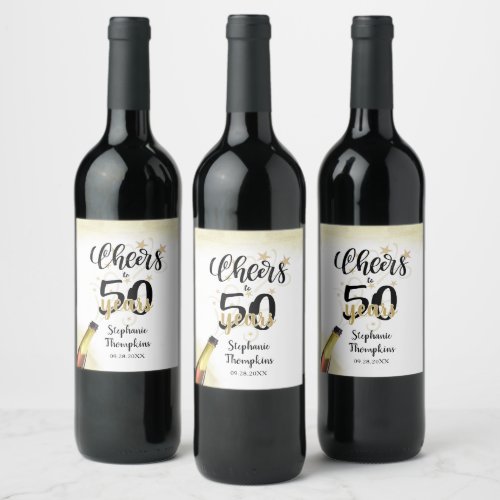 Birthday CHEERS TO # YEARS Black Gold Script Wine Label - Celebrate any age birthday with these fun and festive editable age CHEERS TO # YEARS birthday wine or beverage labels in black and gold with a celebratory drink from a wine, beer or champagne bottle, modern handwritten script typography and your custom text. The sample shows age 50 but can be changed to any age. Ideal for adult birthdays for him or her. Contact the designer via Zazzle Chat or makeitaboutyoustore@gmail.com if you'd like this design modified, on another product or would like coordinating items.