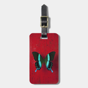 Black and blue butterfly on red wall luggage tag