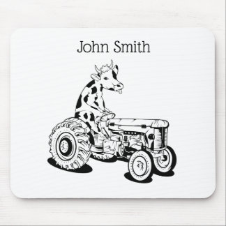 Black and white cow driving a tractor mouse pad
