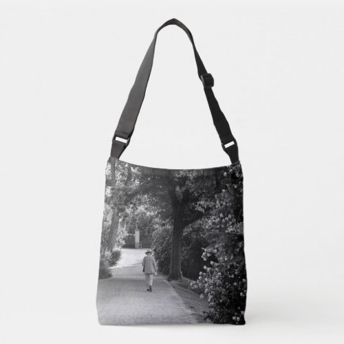 Black and white photo of old man at park crossbody bag