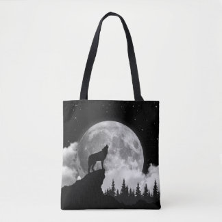 Black and white wolf howling at the moon tote bag