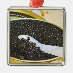 Black caviar and a spoon of mother-of-pearl to metal ornament