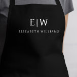 Black Elegant Modern Minimalist Monogram Name Apron<br><div class="desc">Elevate your culinary experience with our Classic Elegant Modern Minimalist Monogram Name Cooking Apron. This kitchen essential seamlessly merges timeless elegance with contemporary minimalism. Crafted with precision, this apron is not just a practical accessory but also a statement of personal style. The customizable monogram and name option allows you to...</div>