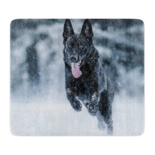 Black German Shepherd in snow Duvet Cover Cutting Board