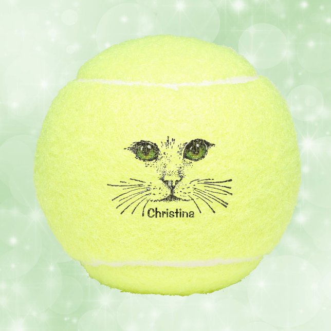 Black Illustration of Face of Cat Green eyes Tennis Balls (Black illustration of a cat face with green eyes and long whiskers on tennis balls.)