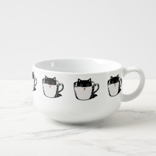 Black kitten with red nose hiding in a cup