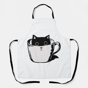 Black kitten with red nose hiding in a cup apron
