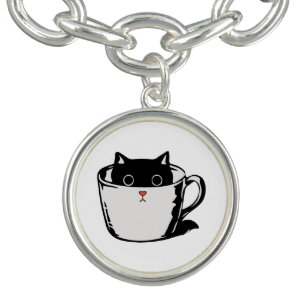 Black kitten with red nose hiding in a cup bracelet