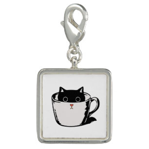 Black kitten with red nose hiding in a cup charm