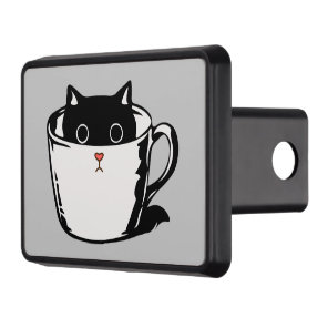 Black kitten with red nose hiding in a cup hitch cover