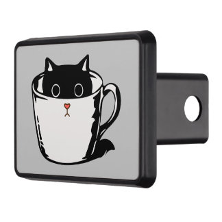 Black kitten with red nose hiding in a cup hitch cover