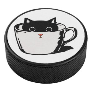 Black kitten with red nose hiding in a cup hockey puck