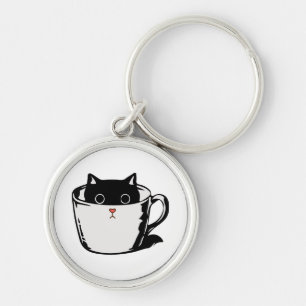 Black kitten with red nose hiding in a cup keychain