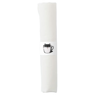 Black kitten with red nose hiding in a cup napkin bands