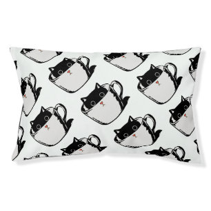 Black kitten with red nose hiding in a cup pet bed