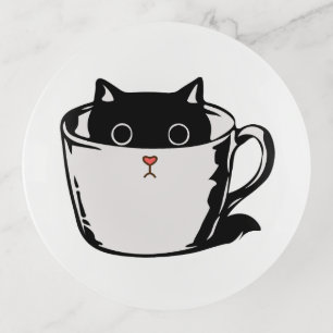 Black kitten with red nose hiding in a cup trinket tray