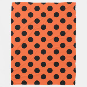 Black polka dots on orange fleece blanket