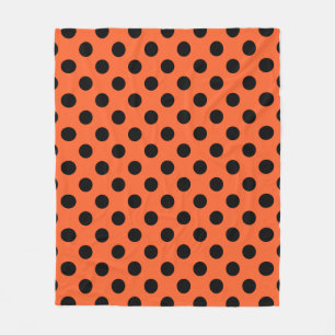 Black polka dots on orange fleece blanket