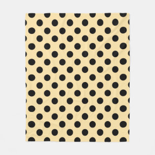 Black polka dots on pale yellow fleece blanket