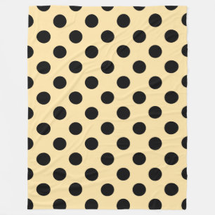 Black polka dots on pale yellow fleece blanket